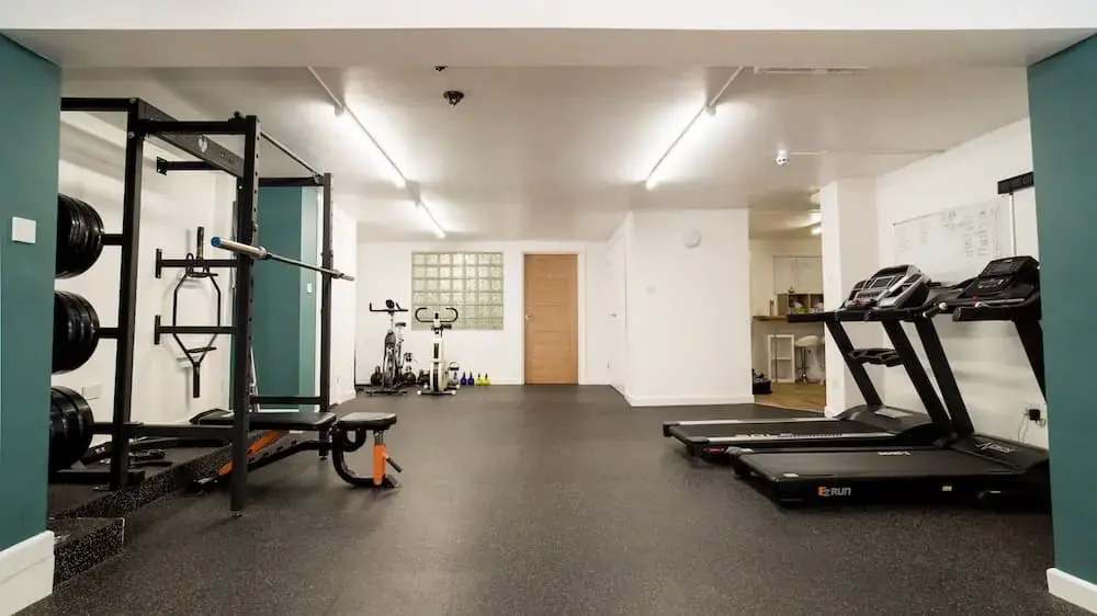 Gym area at Barefoot Physio Exeter with a squat rack and treadmills
