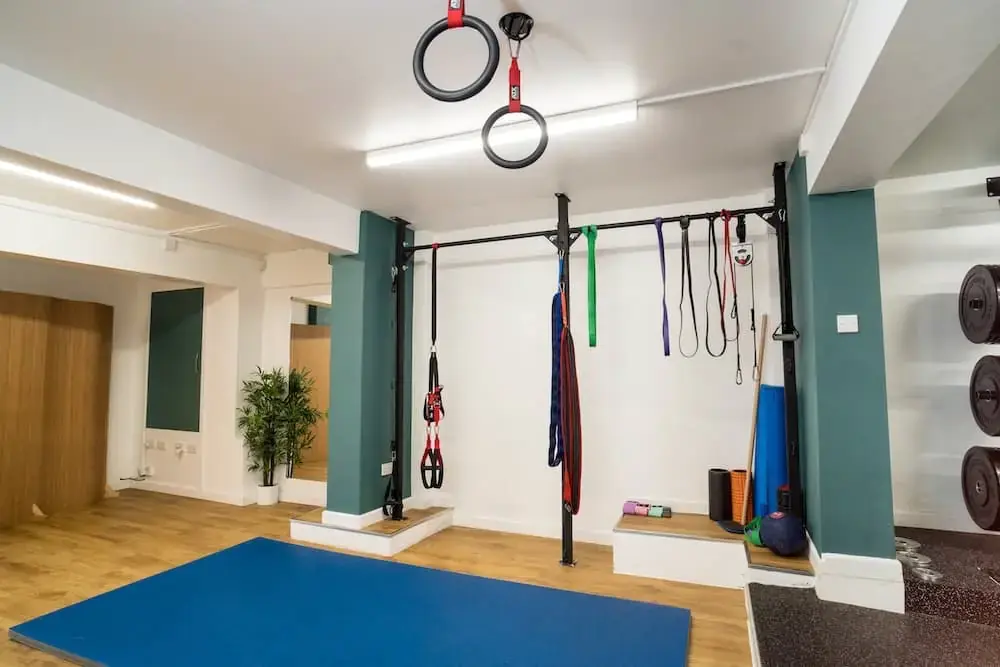 Studio space at Barefoot Physio Exeter with gymnastic rings and exercise mats