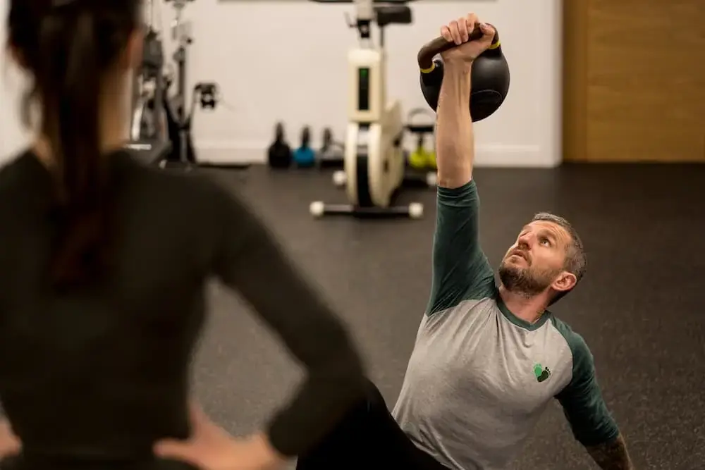 A coach guiding a kettlebell exercise in the Barefoot gym studio